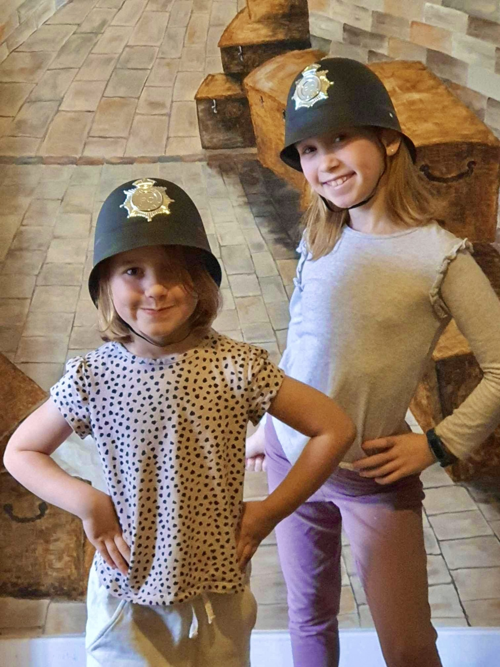 Two young girls wearing police hat costumes.