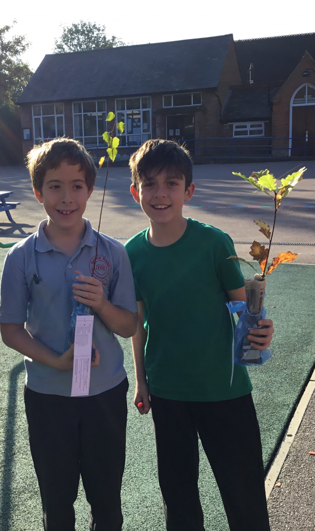 Two schoolboys holding plants