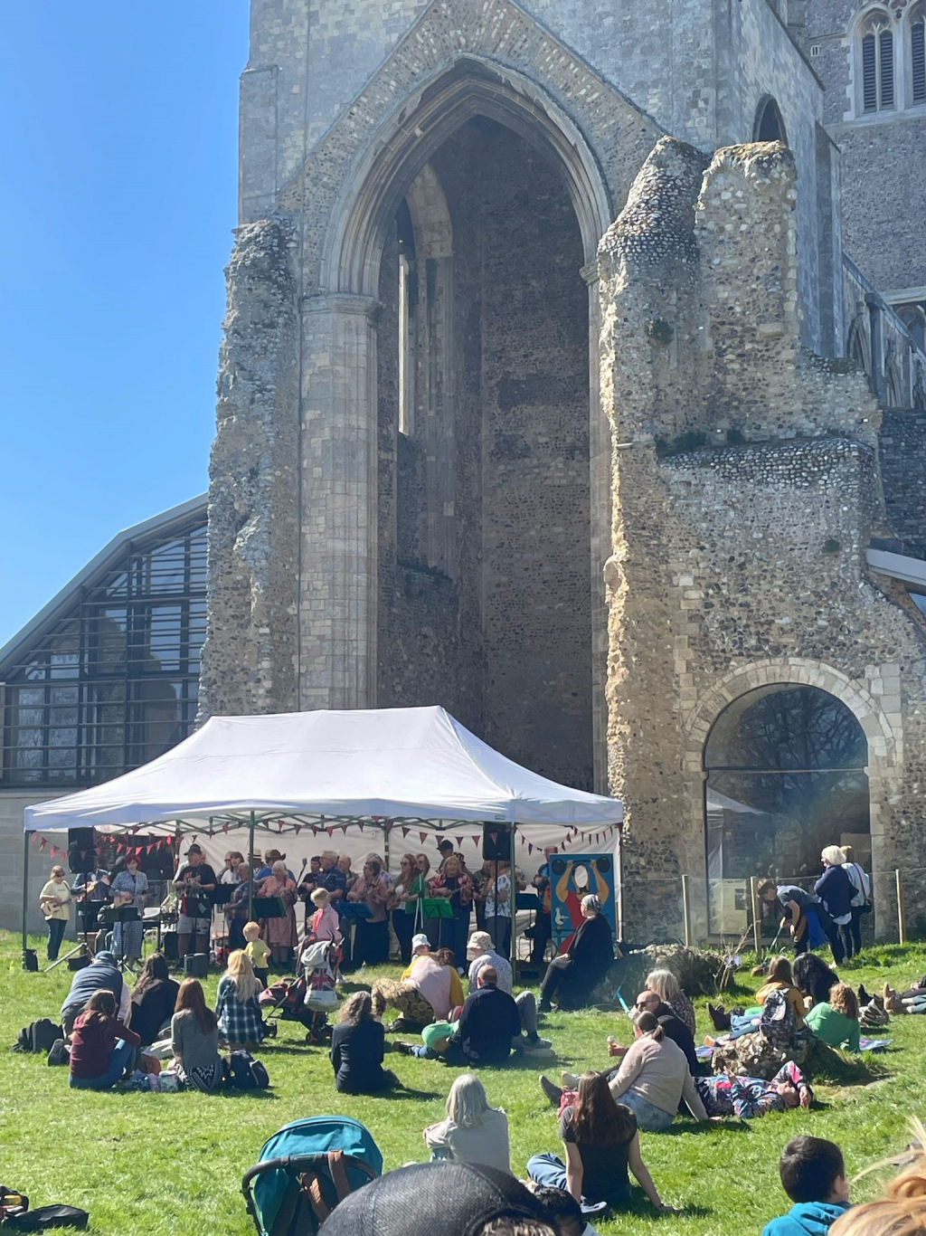 Crowds sitting outside an abbey