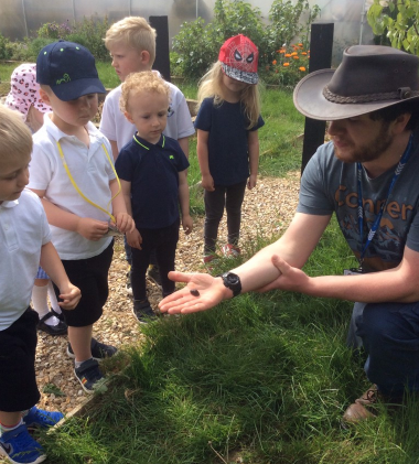 Farmer shows insect to nursery children