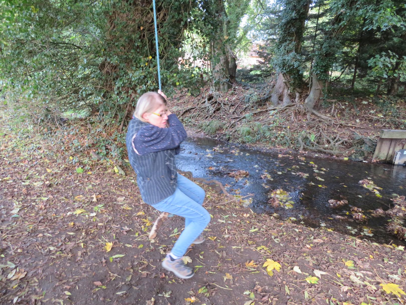 Lady on rope swing by river