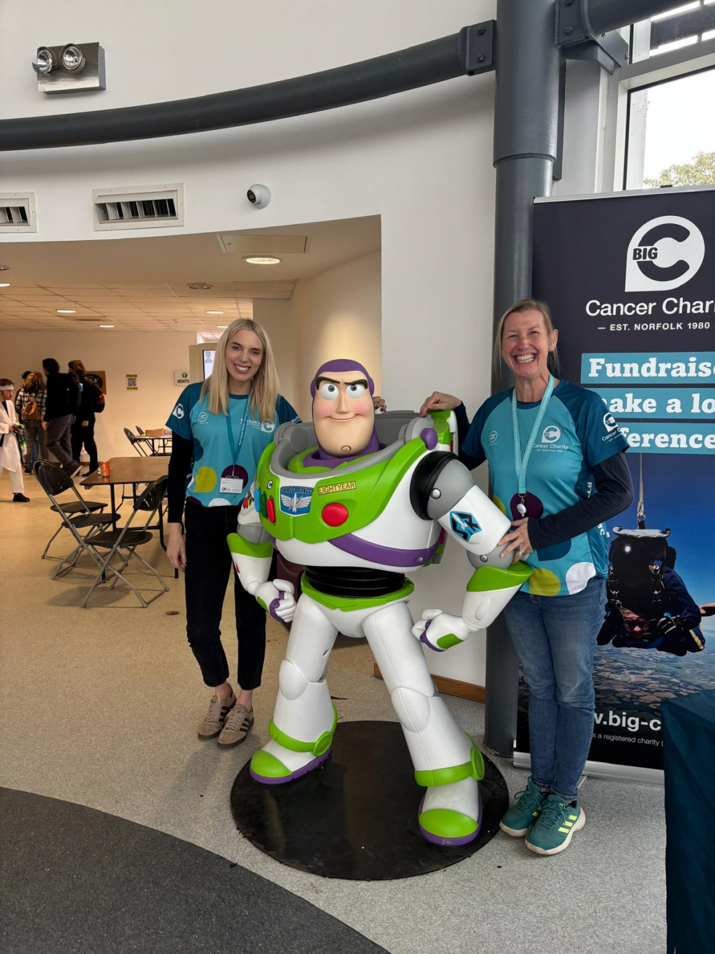 Two women standing by a massive Buzz Lightyear