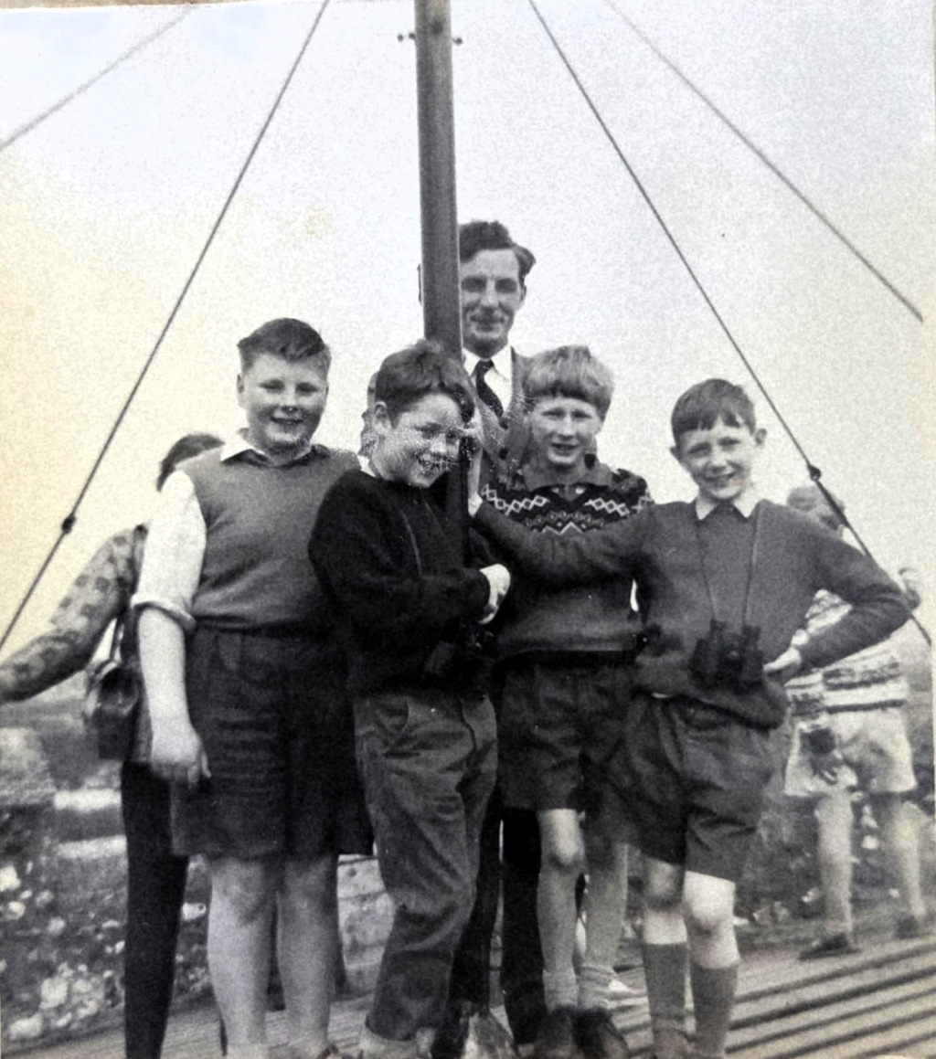 Black-and-white still of boys on a boat