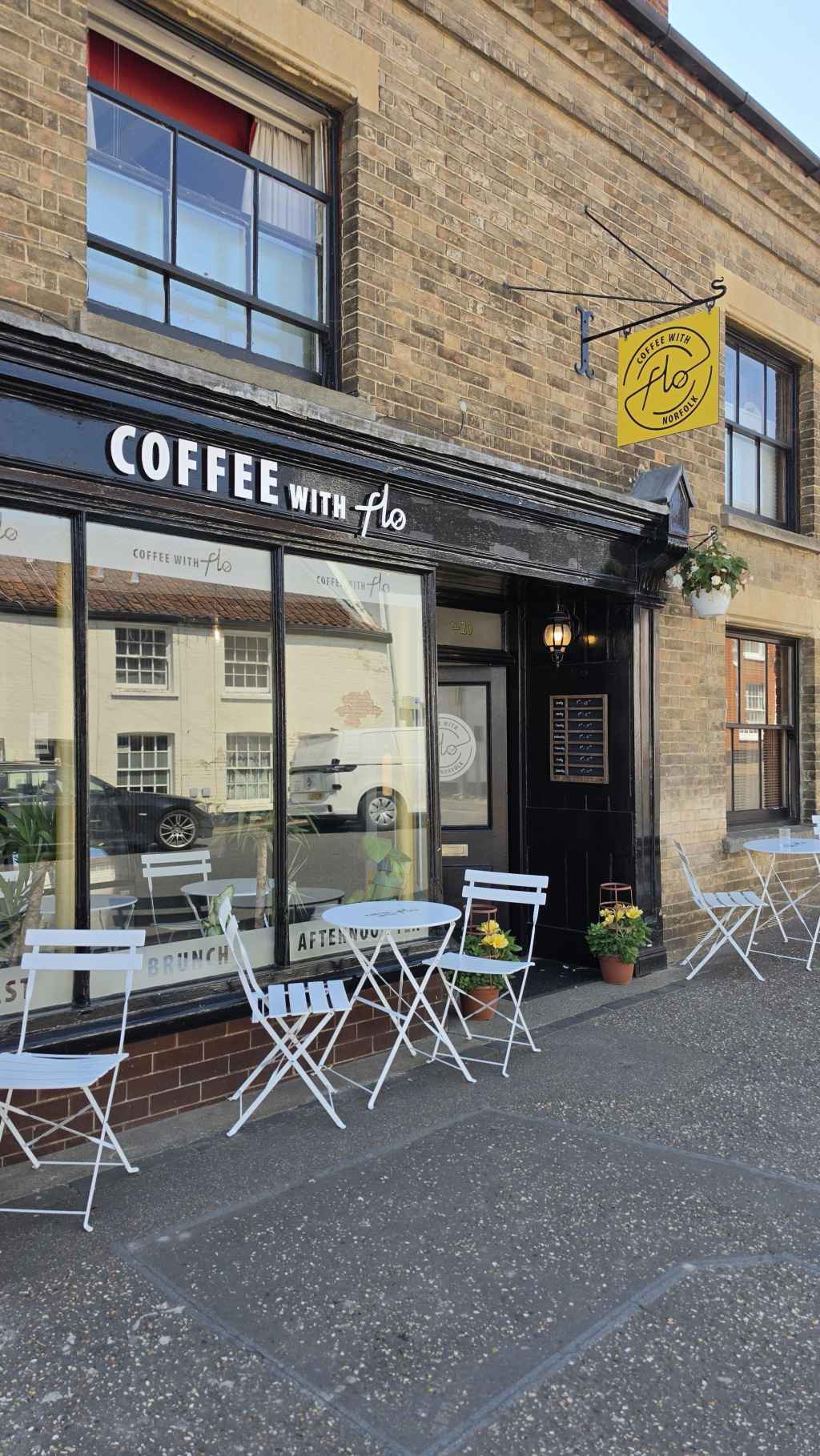 A 'coffee with flo' shop front with chairs outside it