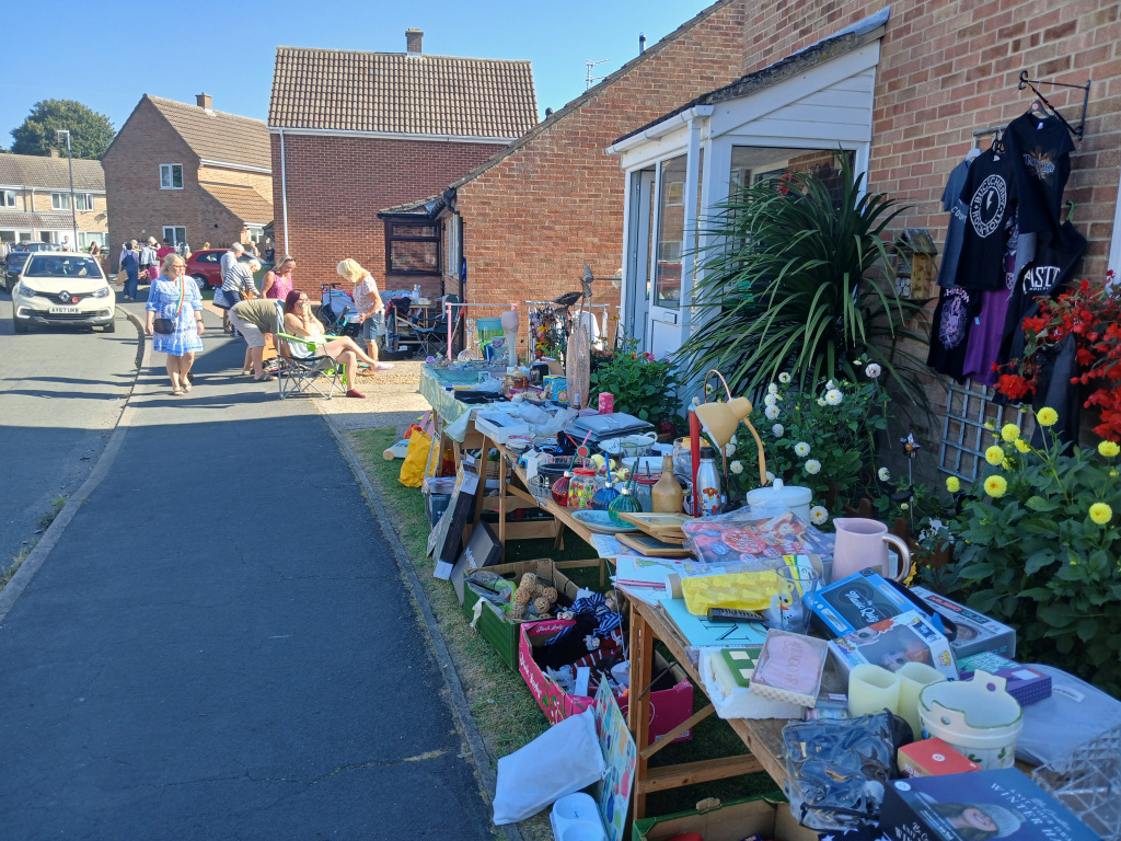 People on a street looking at a table full of goods