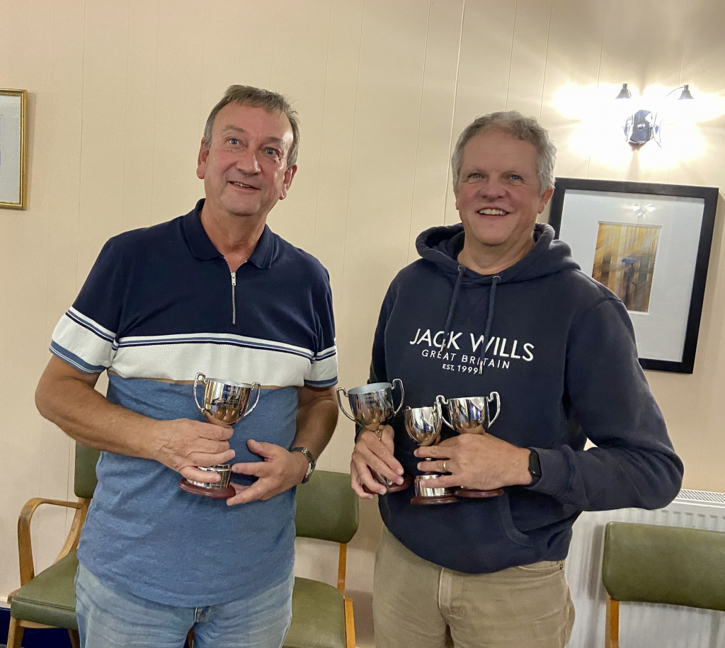 Two men holding trophies