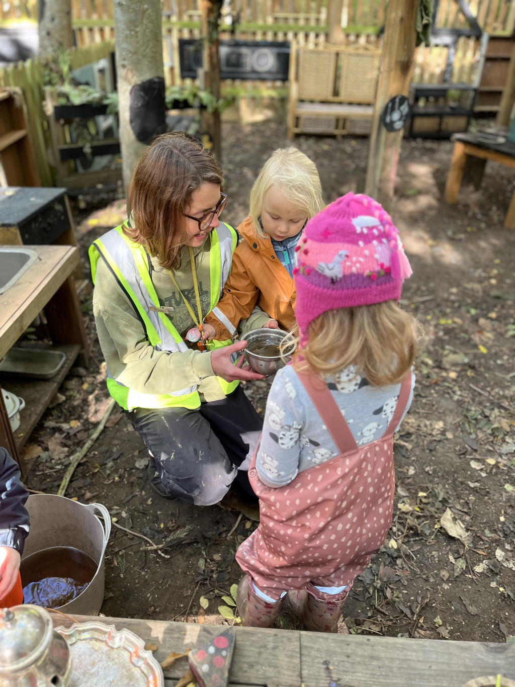 A builder showing her tools to two children