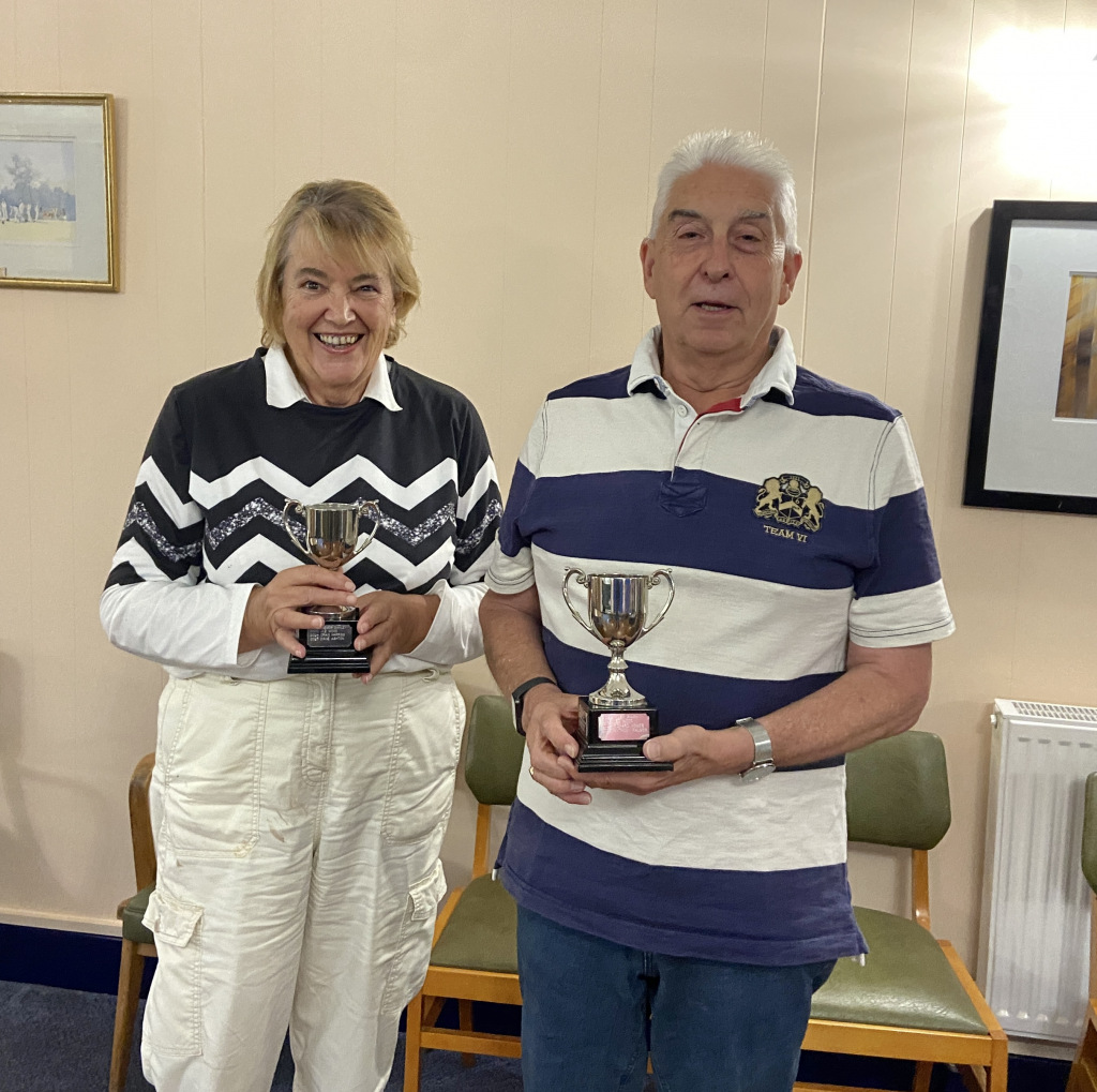 Two people holding trophies