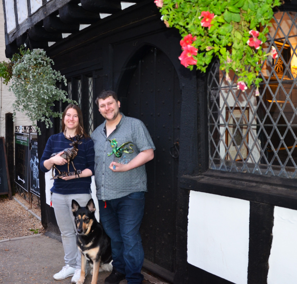Lady, man and dog post outside old pub