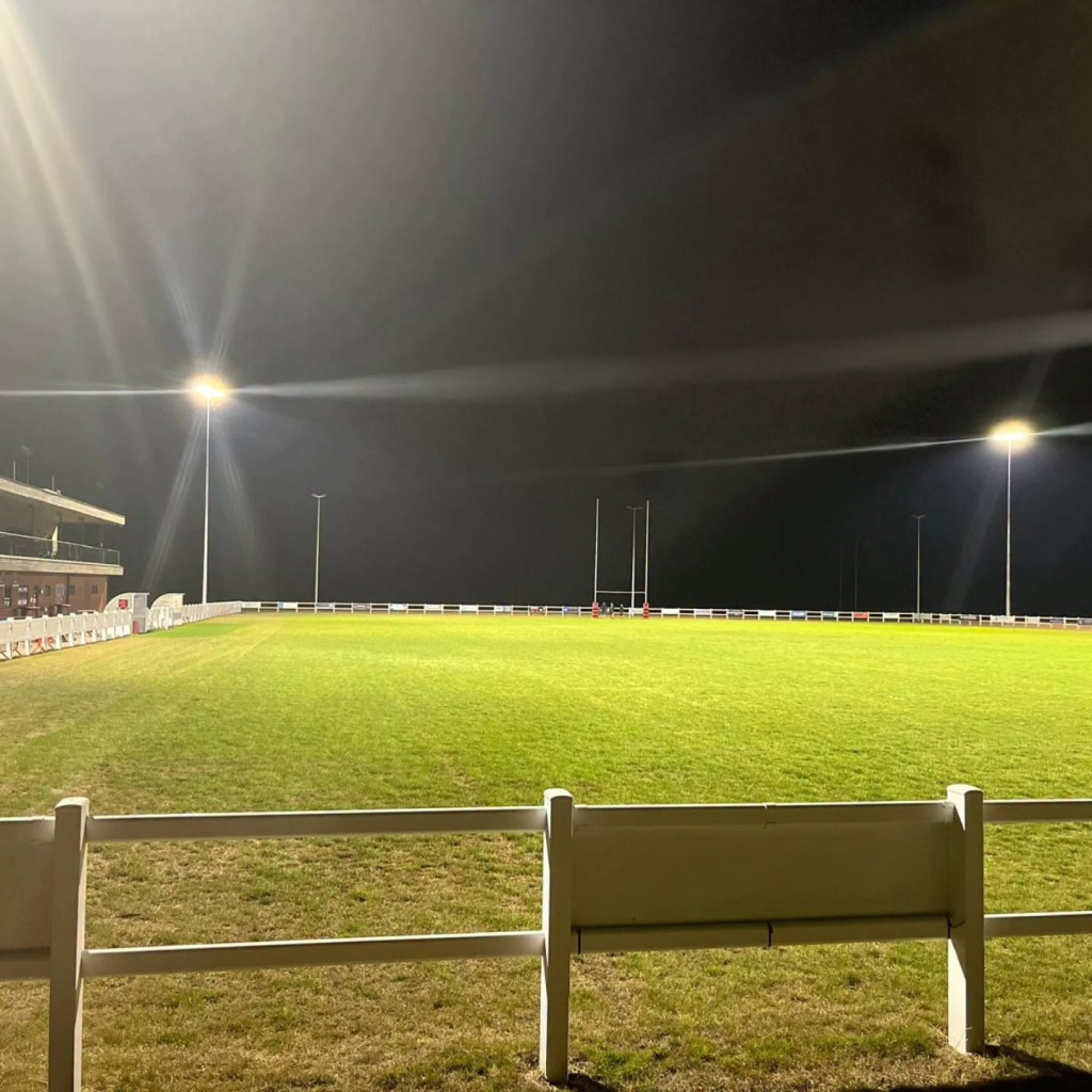 A lit-up-at-night green rugby court