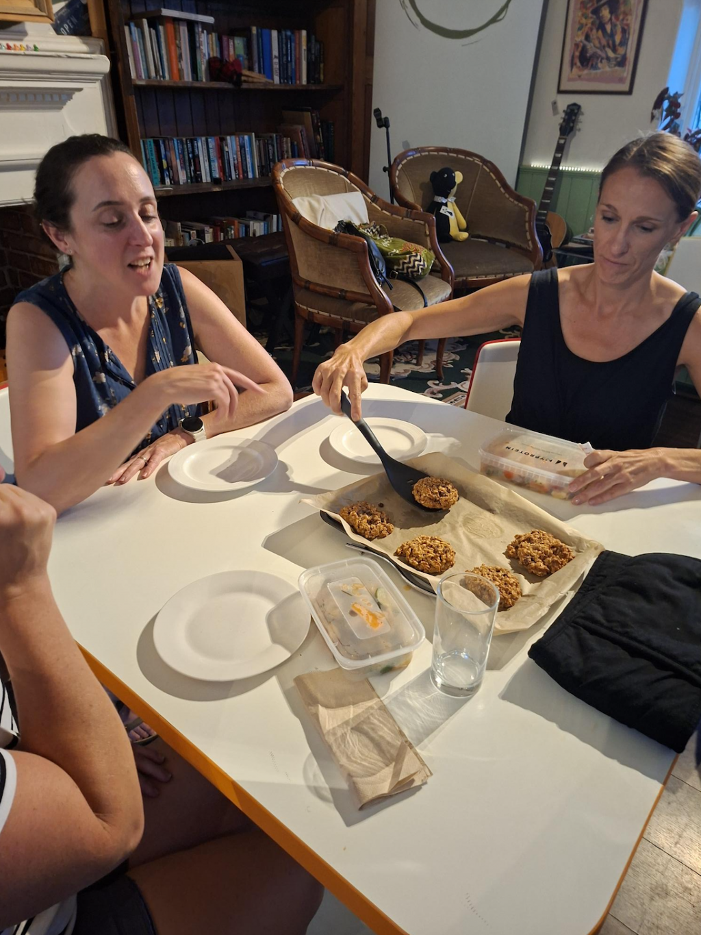 Women around a table slicing cake