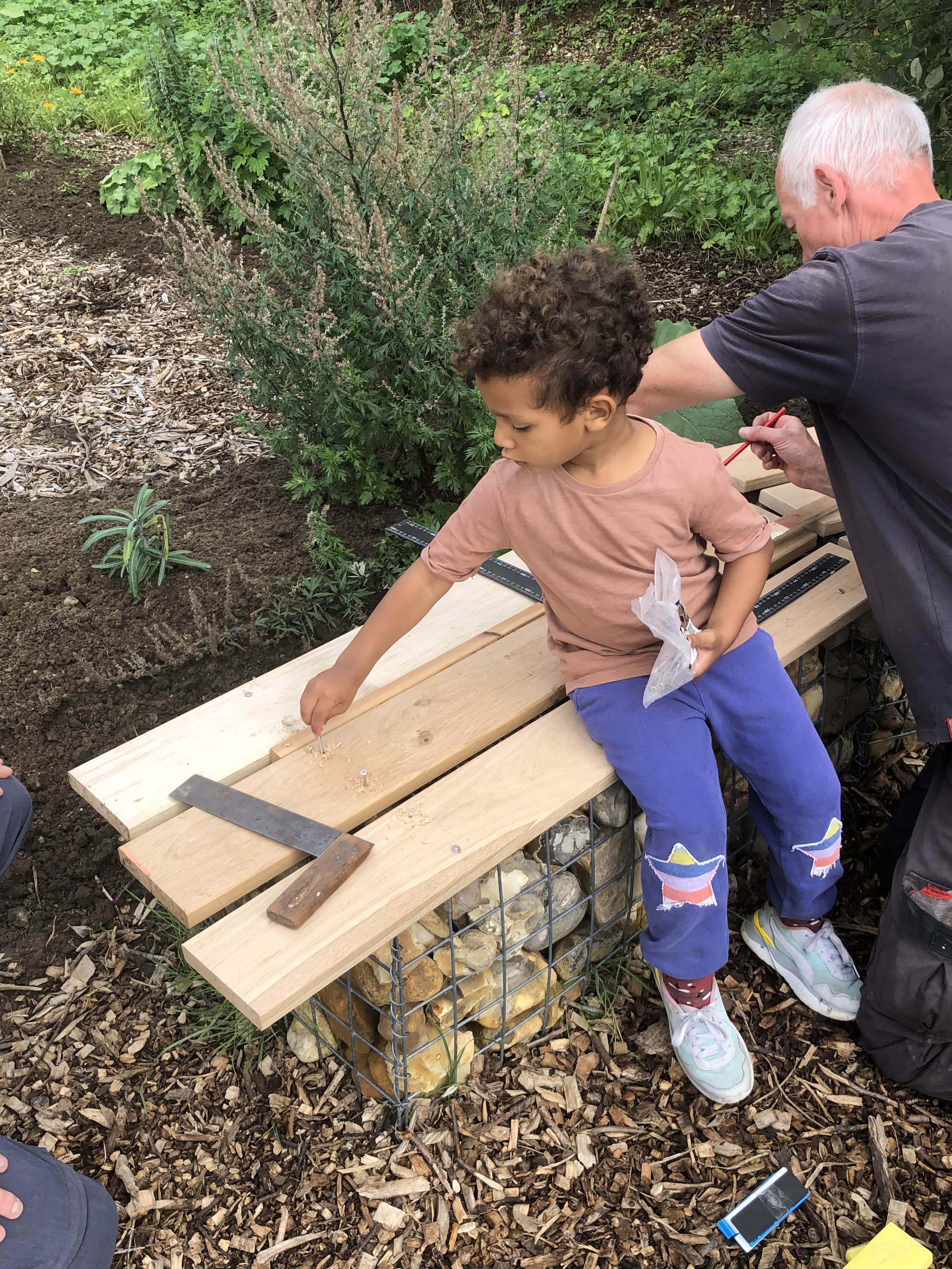 Child helps build bench