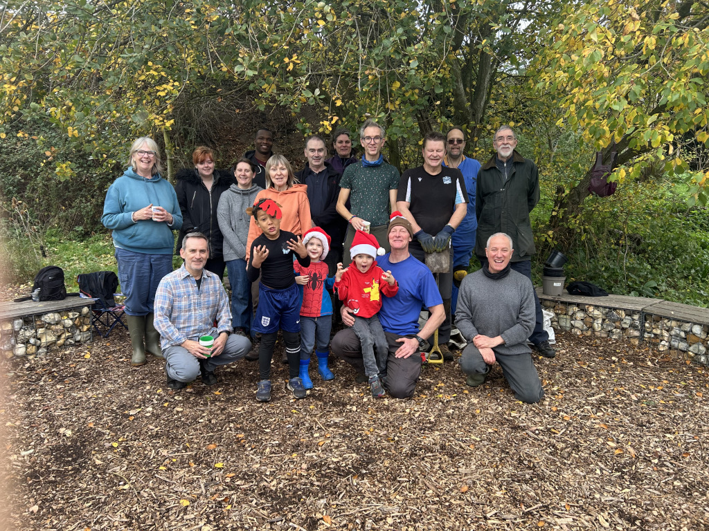 Group of people posing for a photo with Santa hats