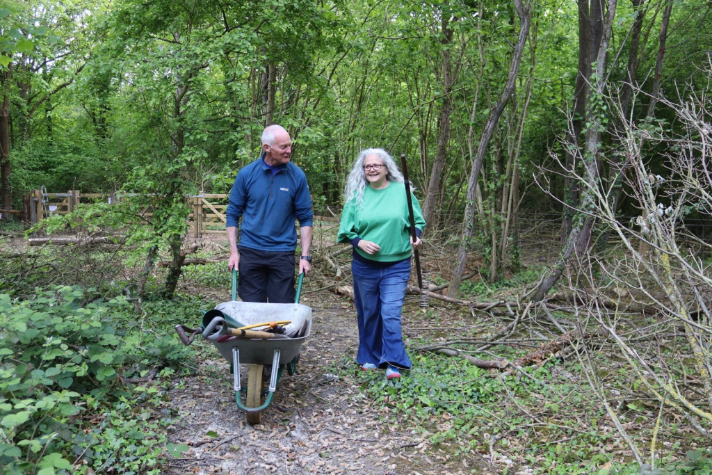 Two people and a dog standing in a wood