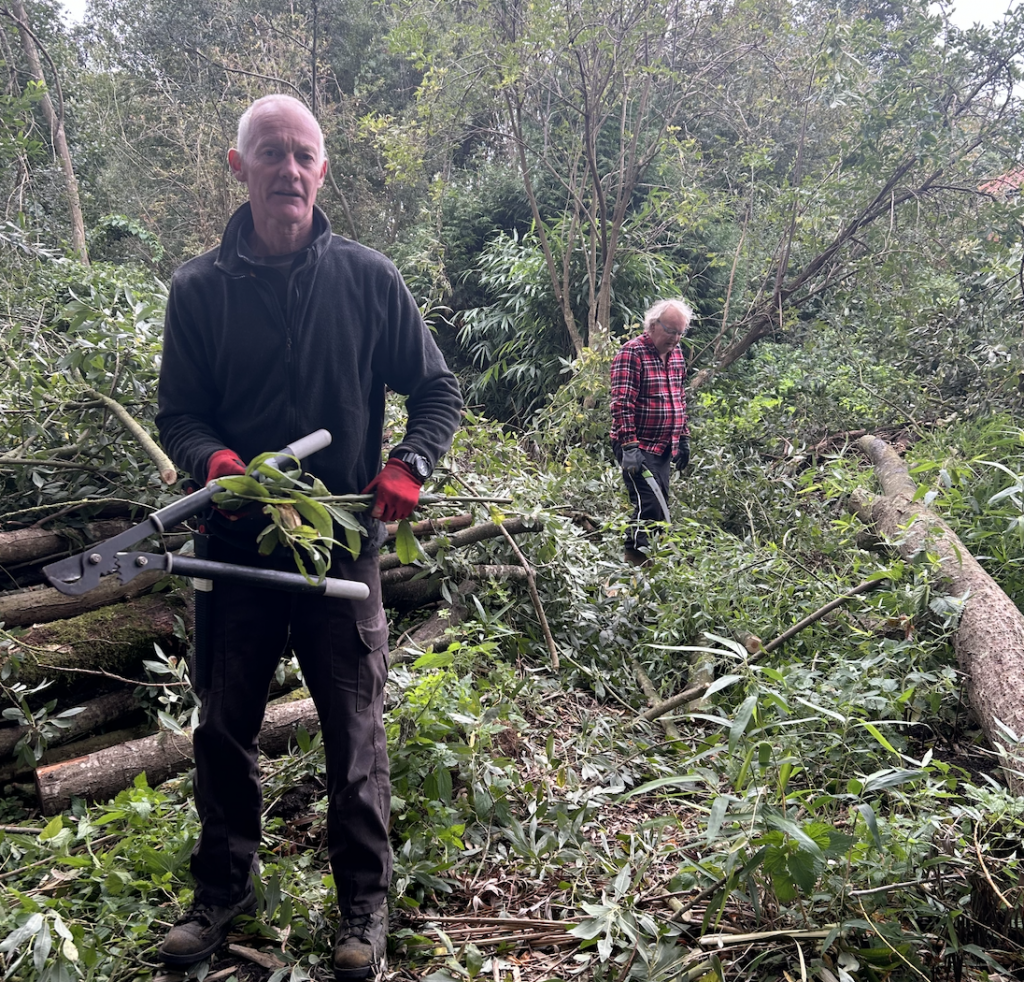 Two men in a forest, one holding pliers