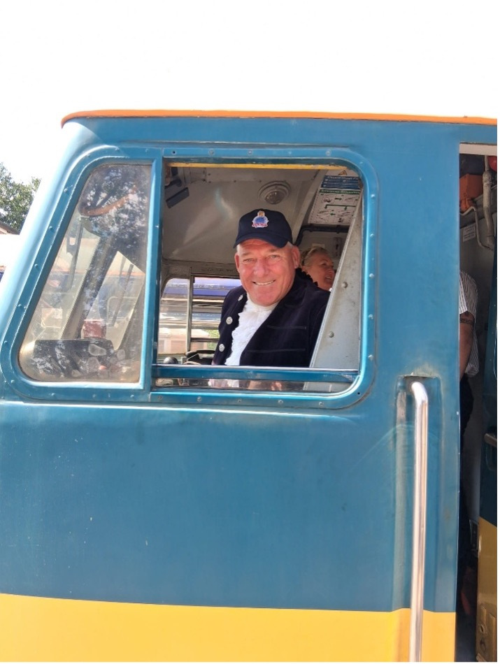 Man smiling out of the window of a train