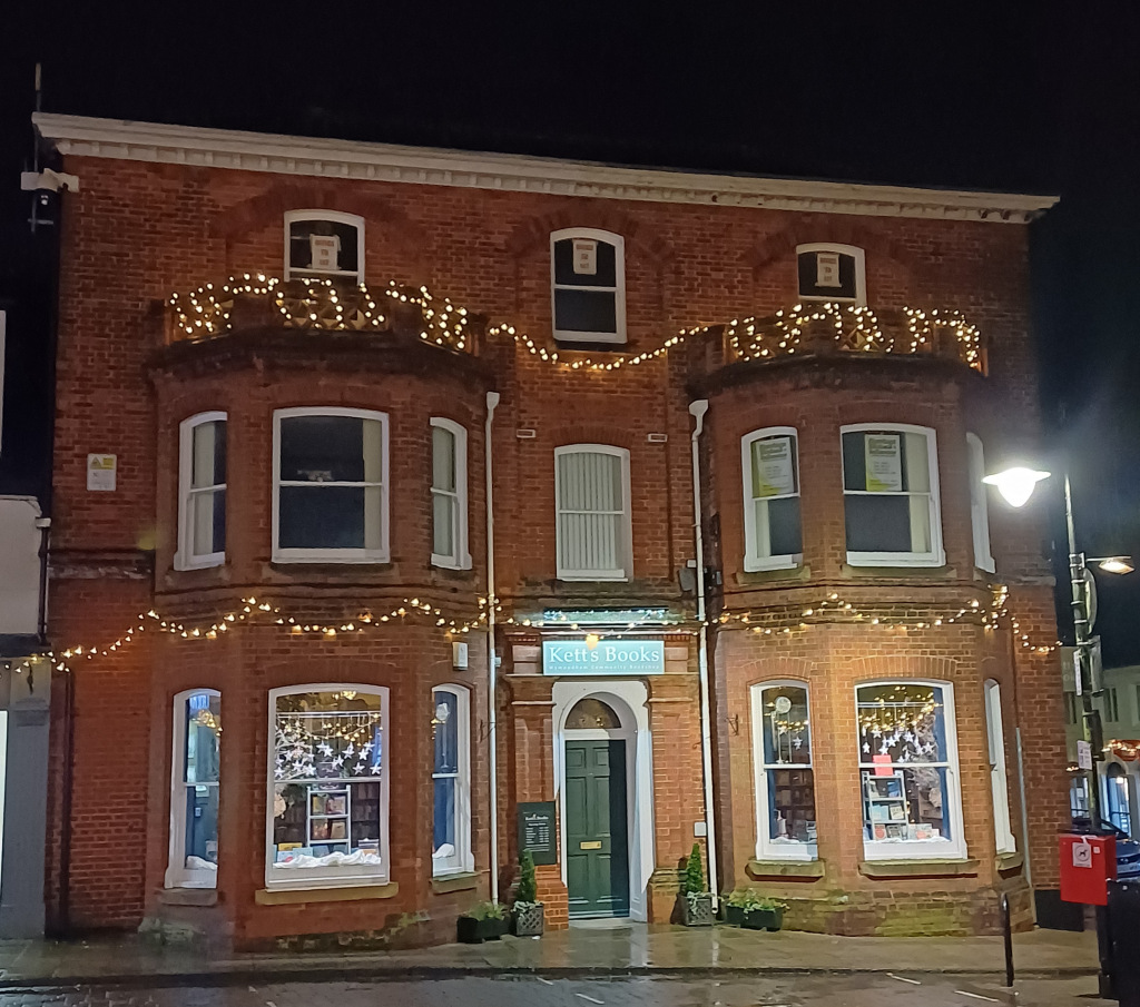 Brick building shop front at night with christmas lights