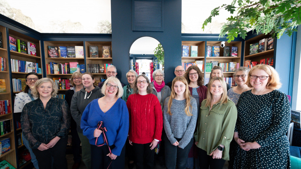 Group of smiling people in book shop