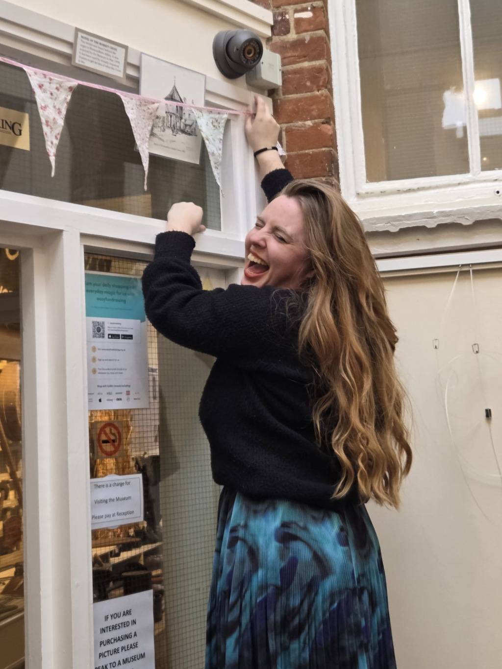 Woman laughing while leaning on a wall