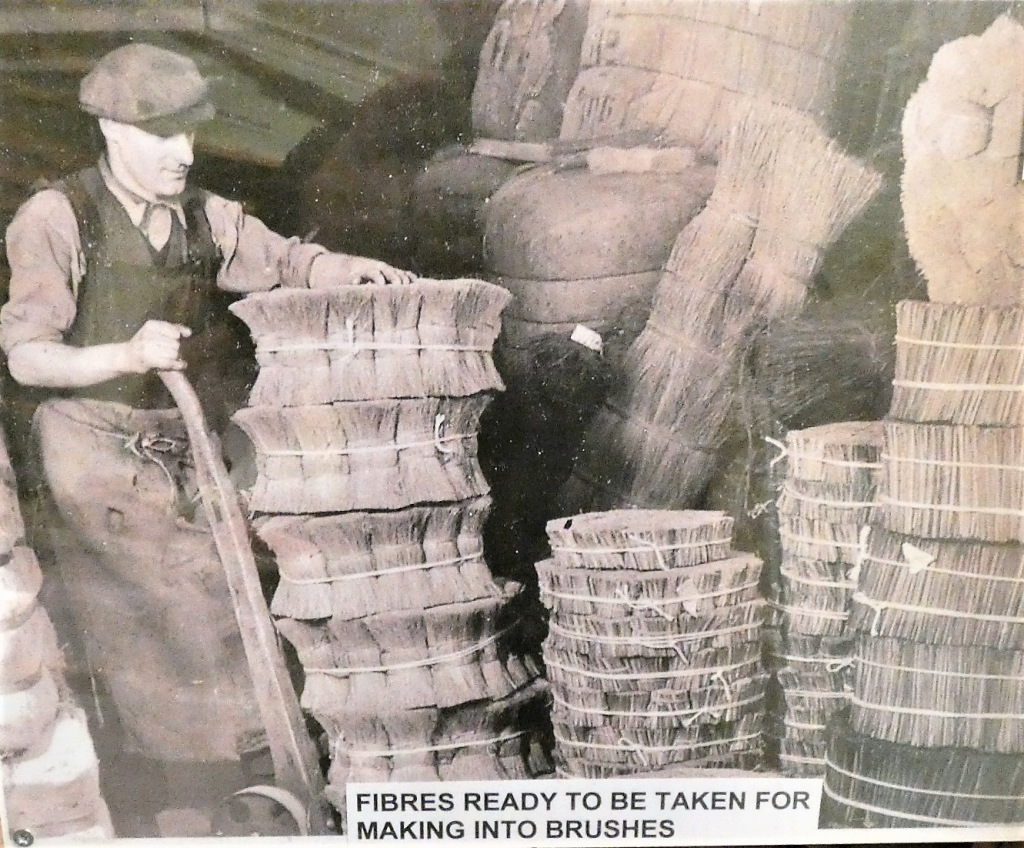 Old photo of man working with fibres for brushes