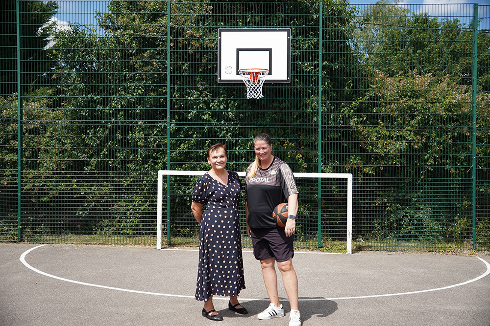 Two women standing on a basketball pitch