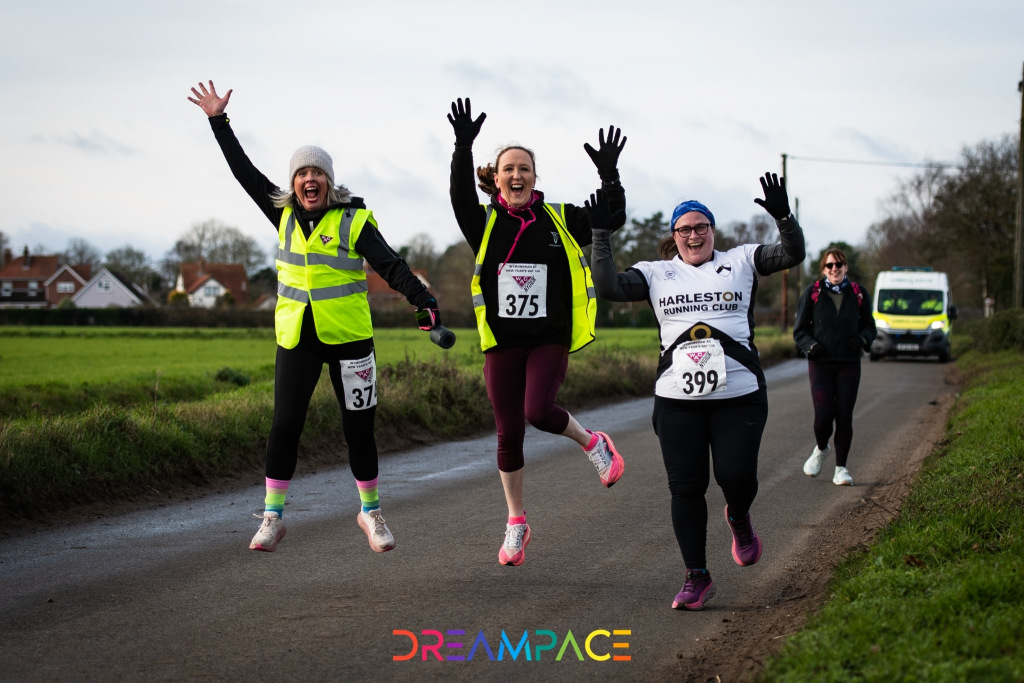 Three women running and jumping in the air
