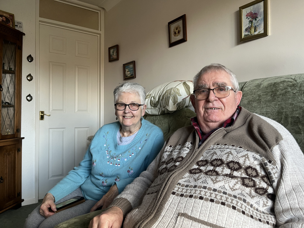 Two elderly people sitting on the sofa