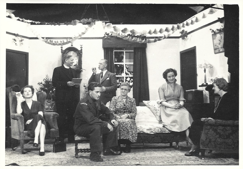 Black-and-white still of a group of actors onstage