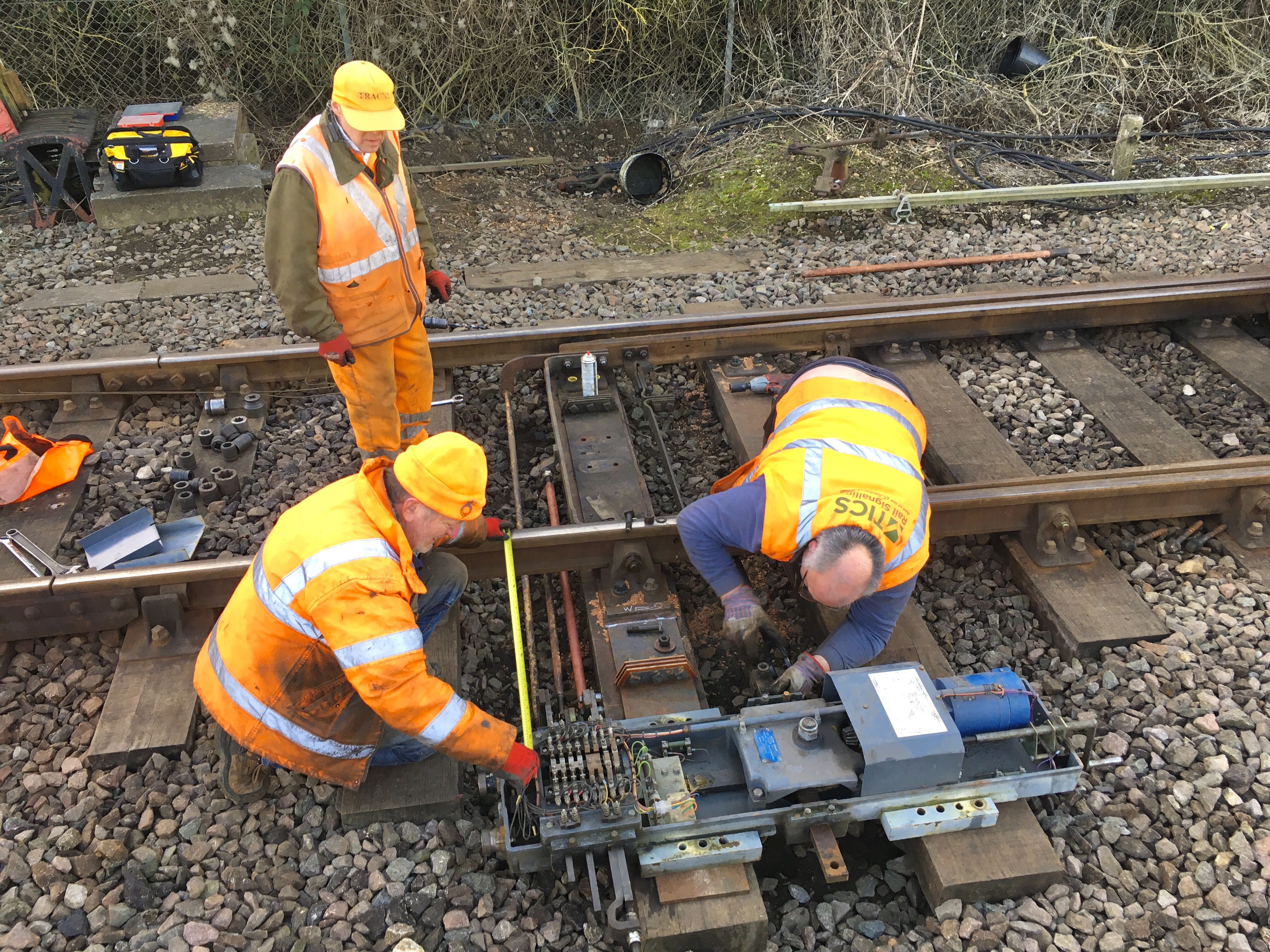 Railway workmen install points motors