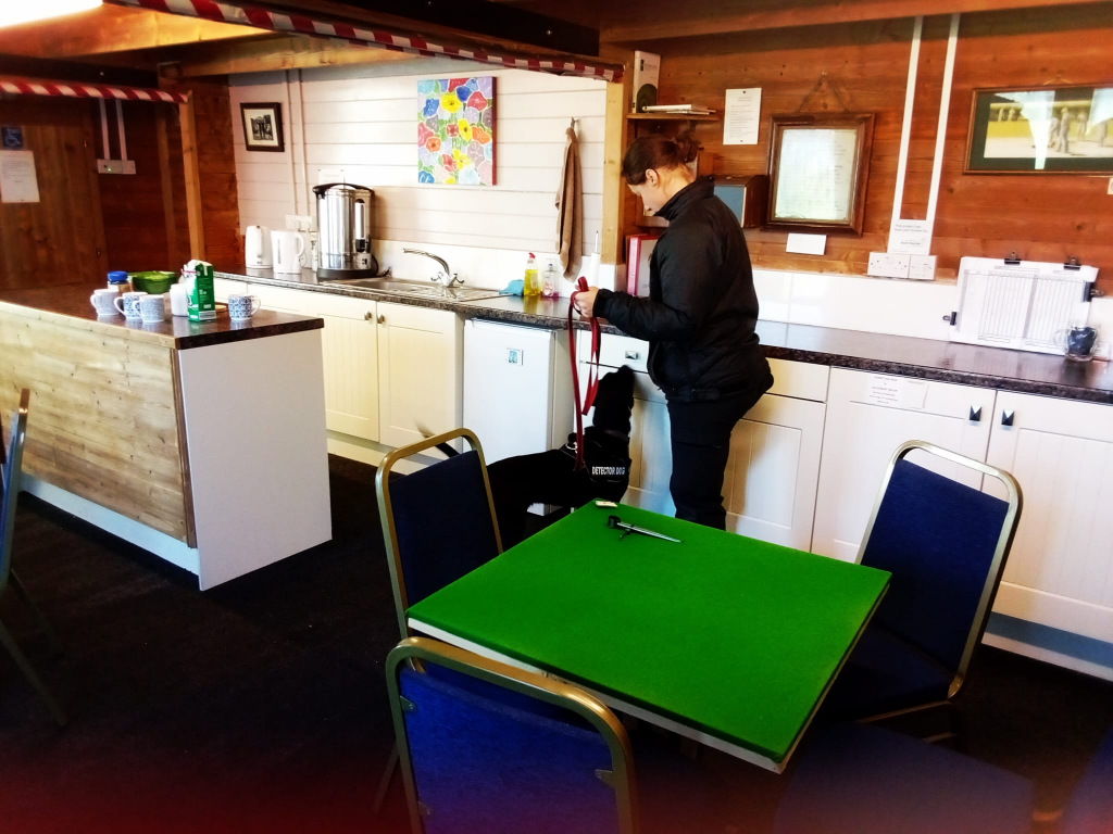 Police officer and a dog investigating a fridge