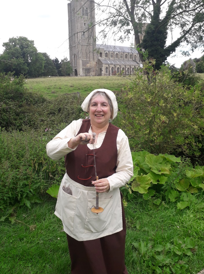 Lady dressed in vintage clothing with abbey in background