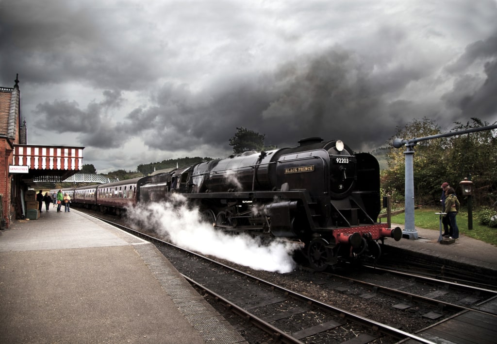 Steam engine 92203 'Black Prince' sitting at a platform at Weybourne station