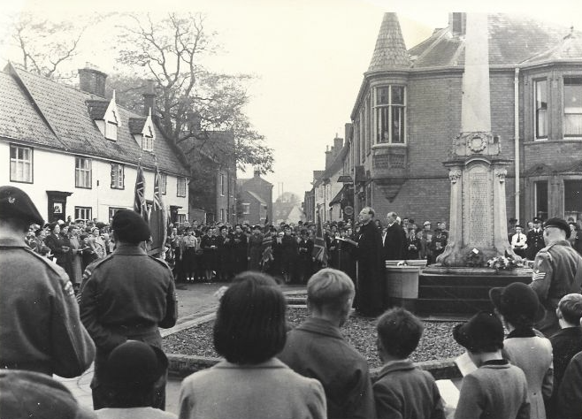 Crowds around Wymondham Town Green monument listening to a vicar