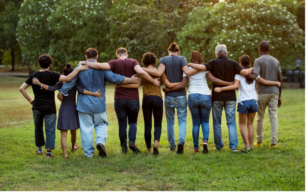 People interlocking arms in a park with their back to the camera