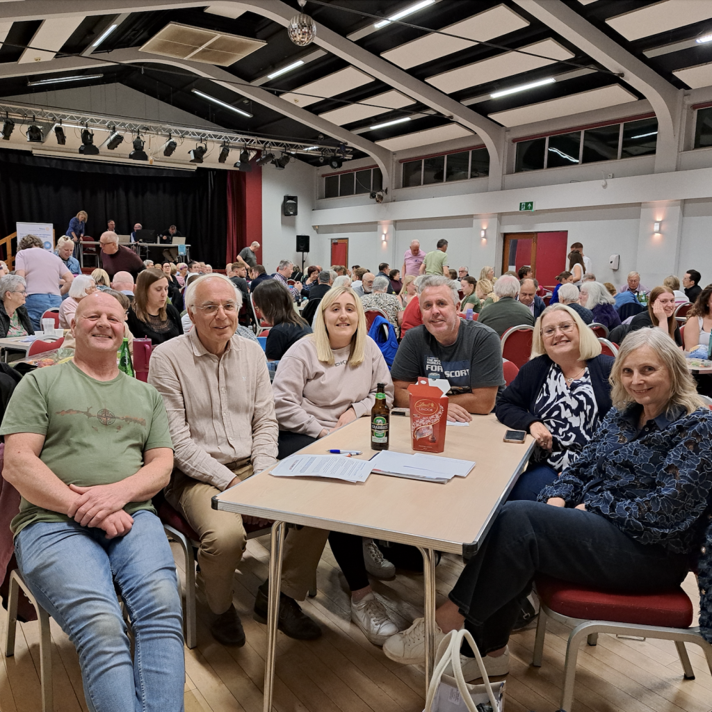 Group of people sat around a table in a busy room