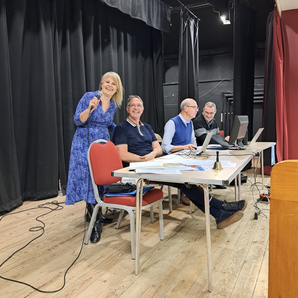 Four people sitting at a table on a stage