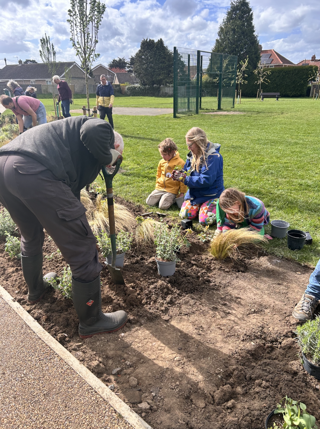 A man and two children on a planting plot