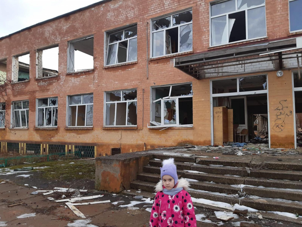 Girl in front of smashed school