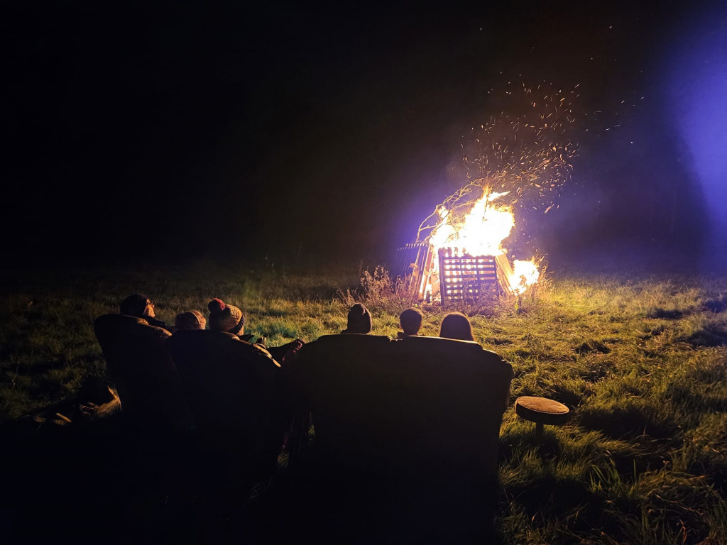 People watching a bonfire at night