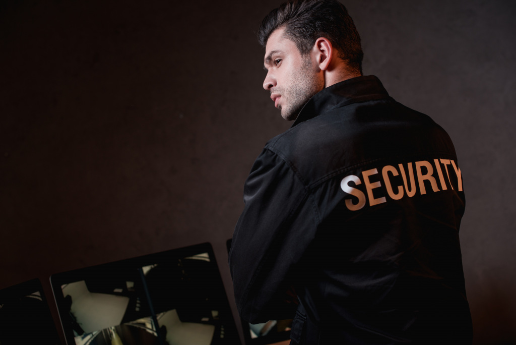 Man with security written on back of black jacket