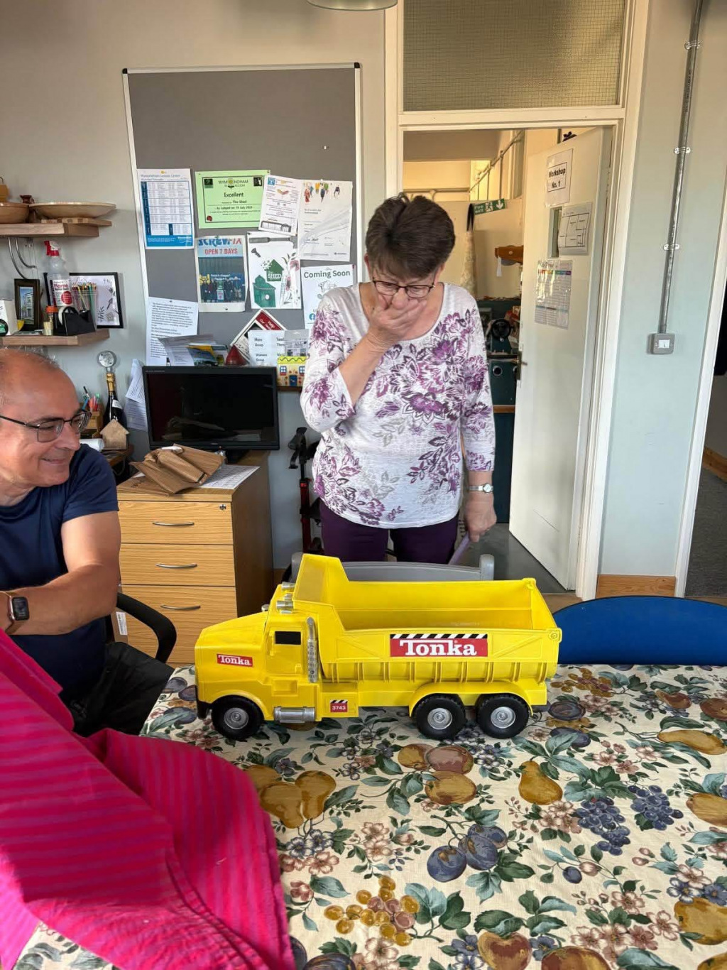 Woman standing by a newly restored toy truck