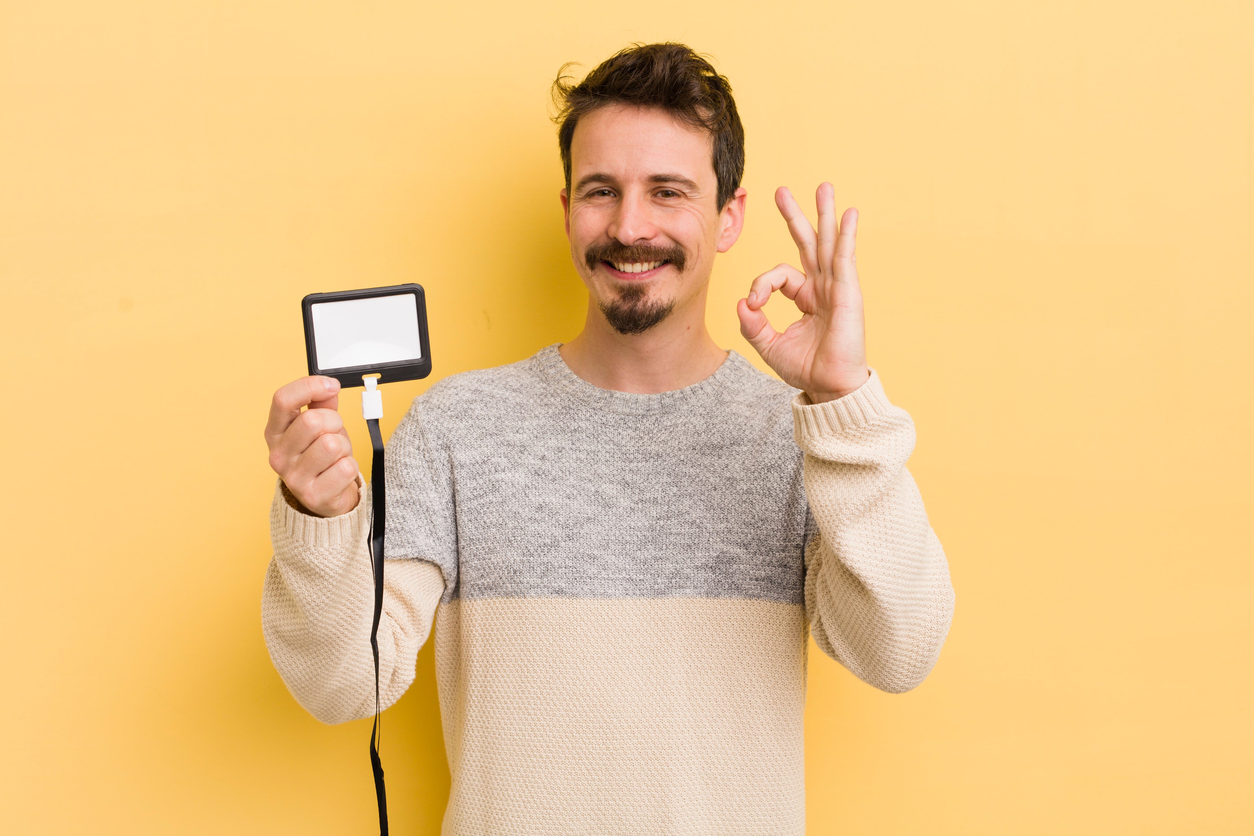 young man smiling showing identification with okay gesture