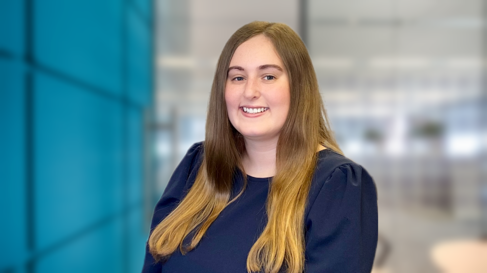 Professional lady smiling with long hair and blue office background