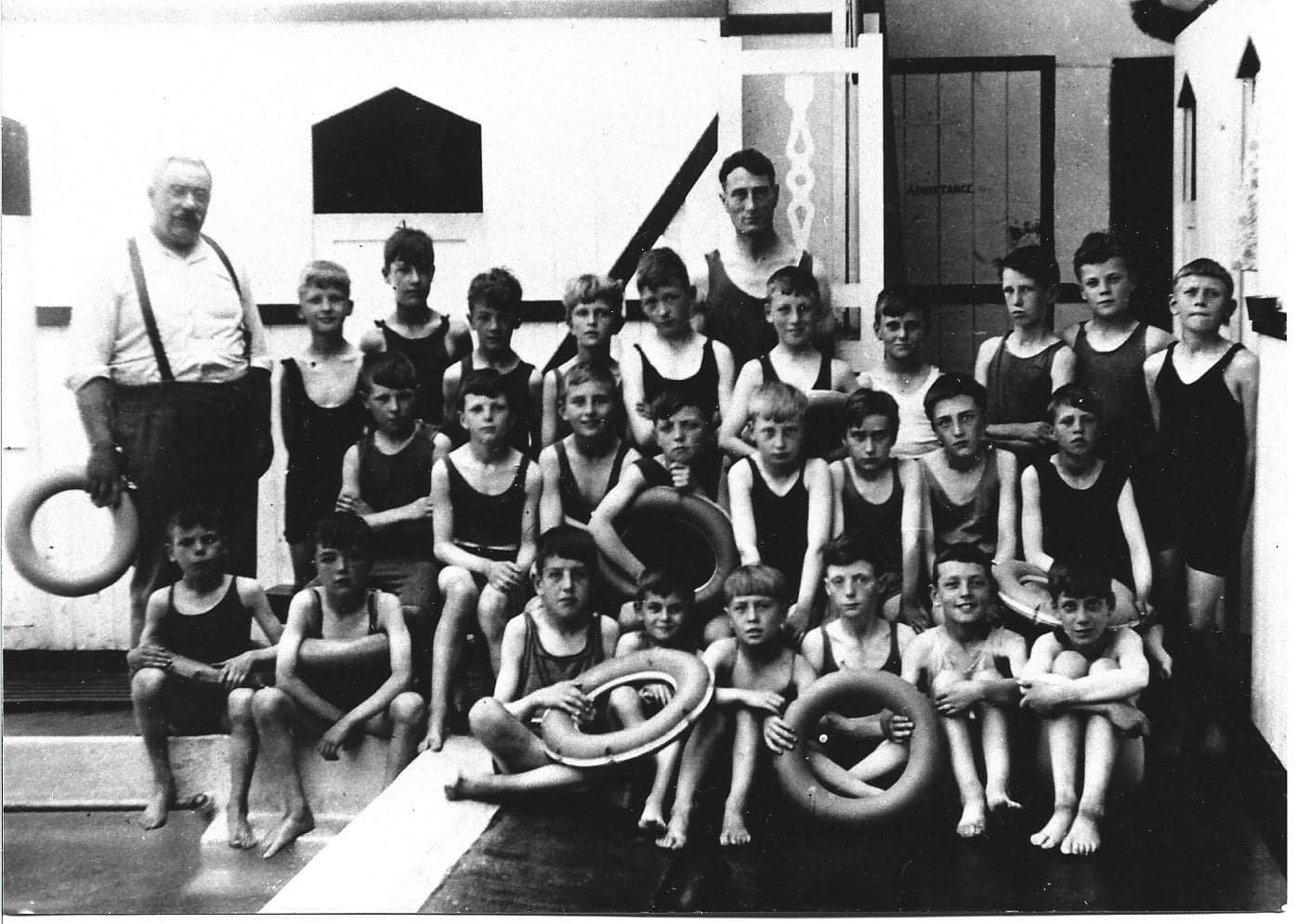 Black and white group photo of children at swimming baths