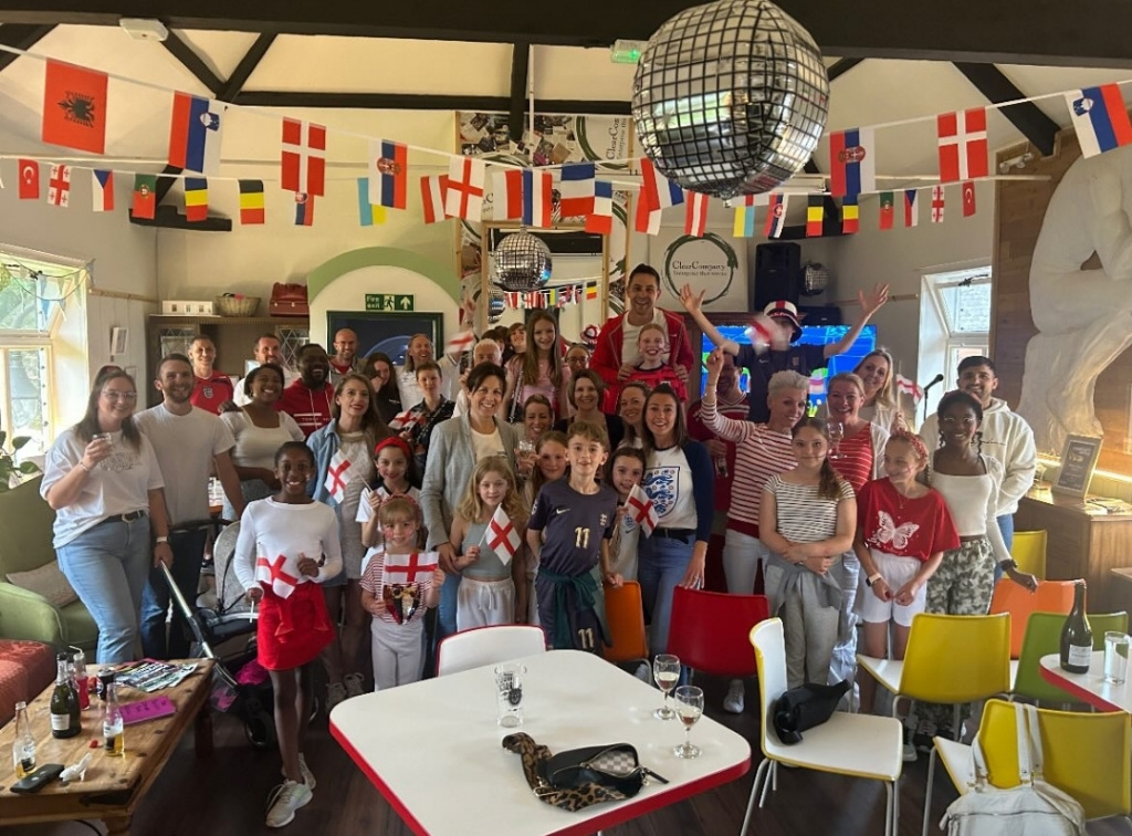 Group of young football fans and adults at an indoor World Cup event