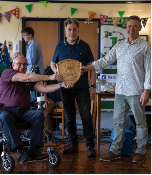Three men holding an award