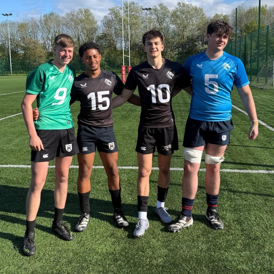 Four boys standing on a sports field