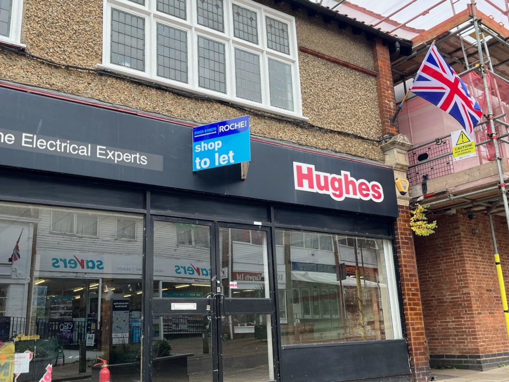 Hughes with a to let sign mounted on it's storefront