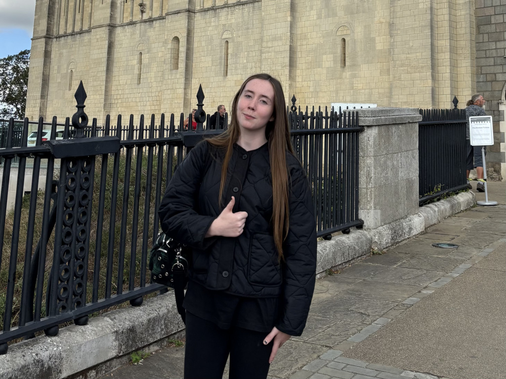 Woman standing on a bridge with a thumbs up