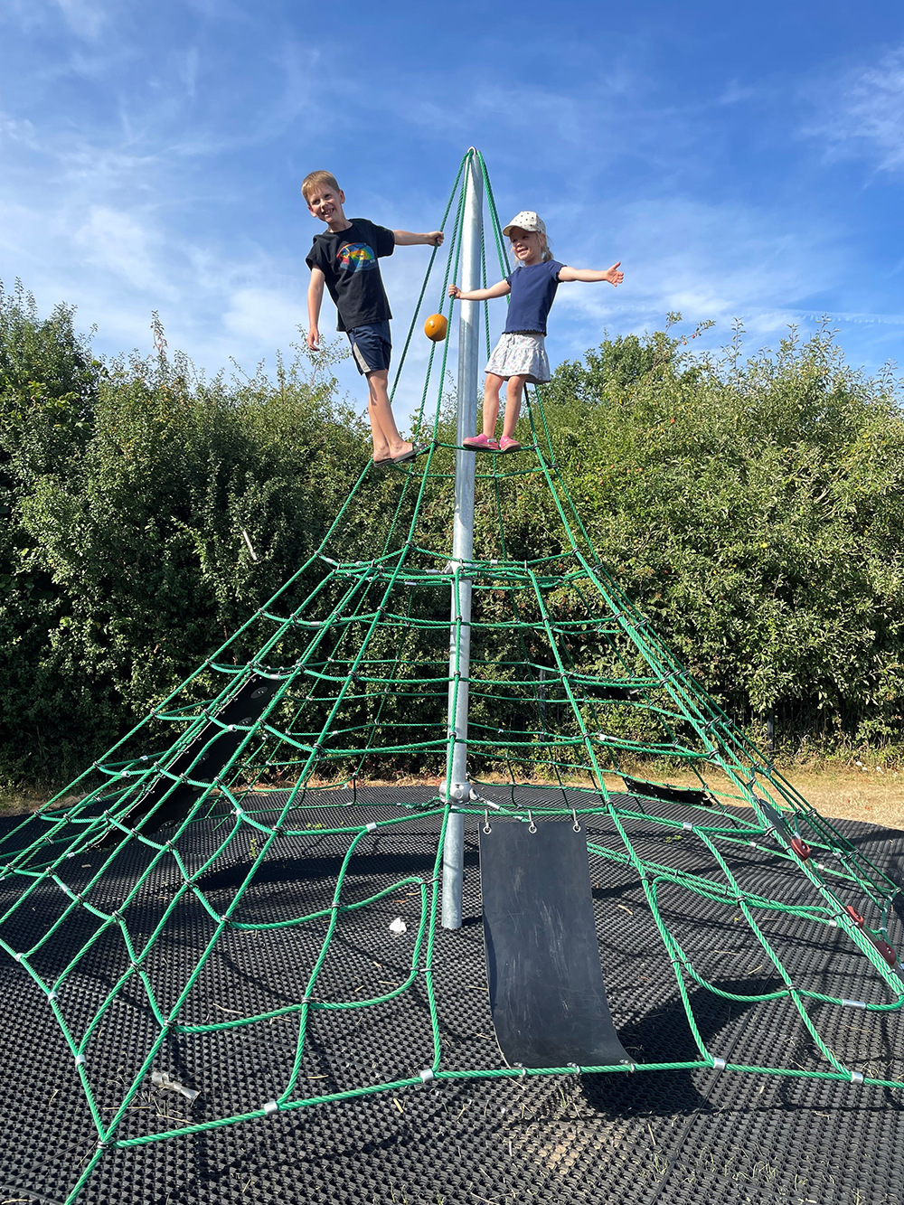 Children on top of a playground netted climbing frame